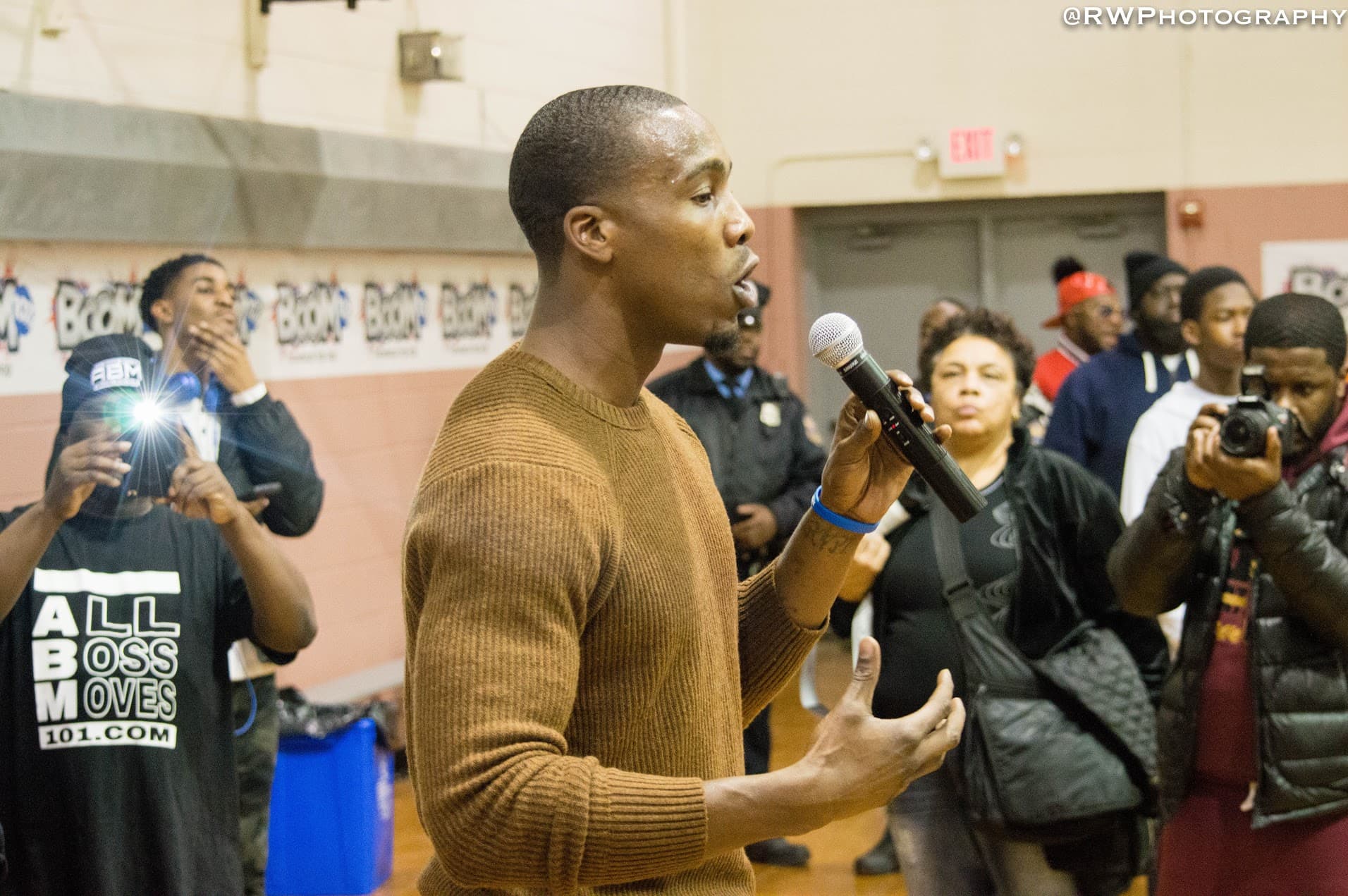 Tasheed Carr speaking to the community at a Born Leader Family event in the gym